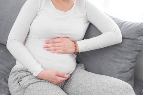 Embarazada cansada mujer agotada con problemas estomacales en casa en un
  - Foto, imagen