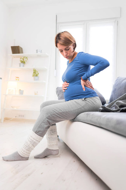 Pregnant tired exhausted woman with stomach issues and back pain - Foto, Imagen