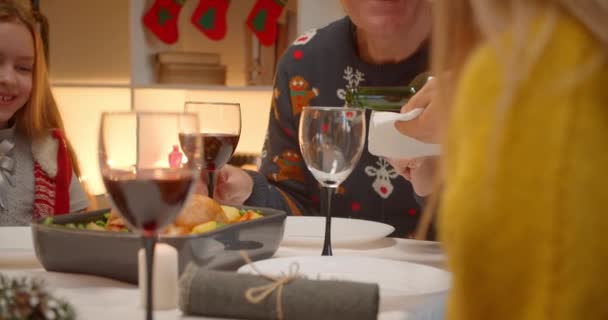 Big friendly family grandparents father pours wine bottle evening christmas - Filmati, video