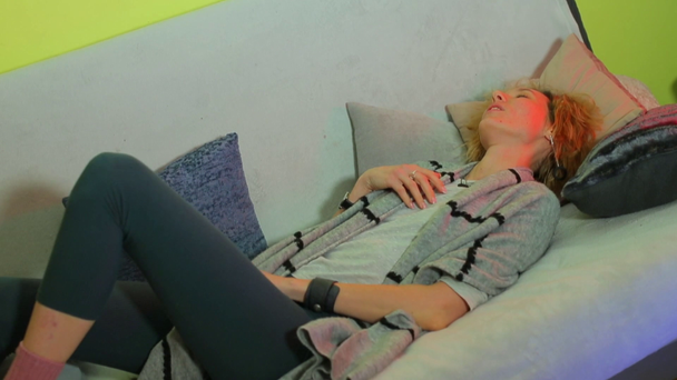 Egy nő lefekszik a kanapéra pihenni.. - Felvétel, videó