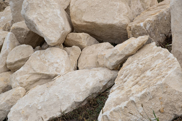 Большая куча больших песчаных камней, лежащих на земле конструкций
 - Фото, изображение