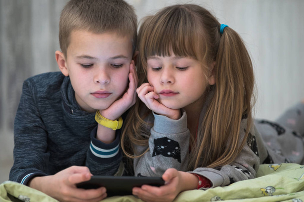 Twee kinderen broer en zus kijken video op smartphone scr - Foto, afbeelding