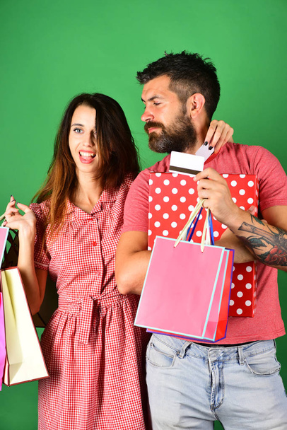 Man with beard holds credit card and polka dotted box - 写真・画像