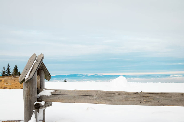 wooden fence in the snow on a background of mountains - Zdjęcie, obraz