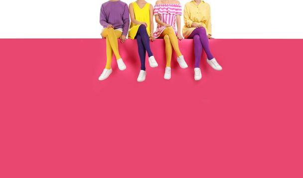 Group of women wearing bright tights and stylish shoes sitting o - Photo, image