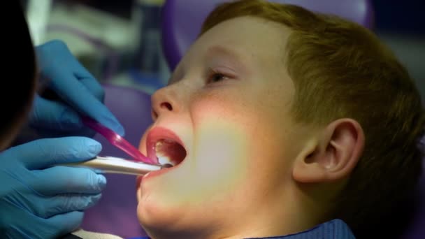 A fogorvos egy rémült vörös hajú fiú fogait kezeli. - Felvétel, videó