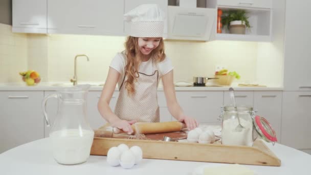 Cute female kid rolling out pastry for homemade cookies - Séquence, vidéo