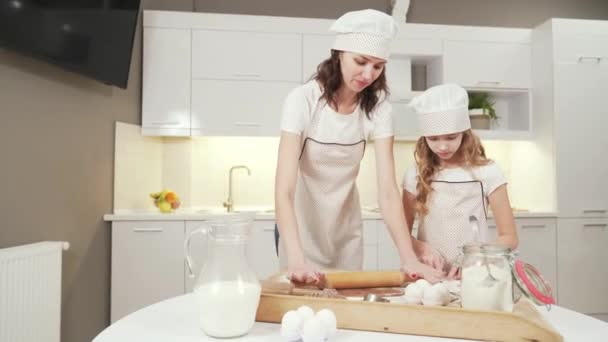 Mother and daughter rolling out pastry for cookies together - Filmati, video
