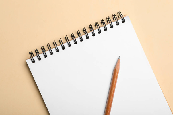 Open notebook and pencil on beige background, top view - Photo, image