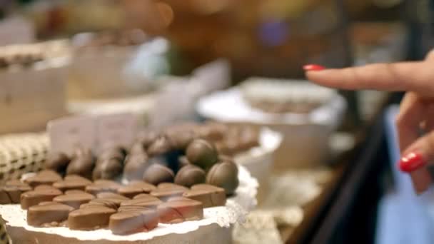 La chica elige el chocolate en la tienda de dulces
 - Metraje, vídeo