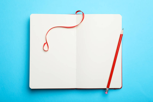 Stylish open notebook and pencil on light blue background, top view - Valokuva, kuva