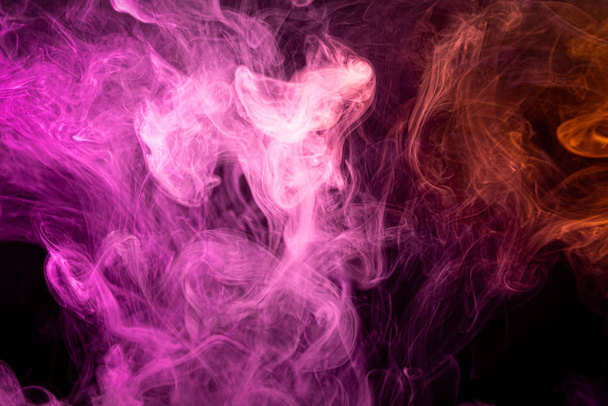 Fumée dense multicolore de couleurs rose et violet, rouge sur un fond isolé noir. Fond du robinet de fumée
 - Photo, image