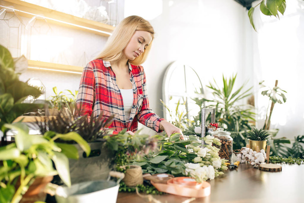 woman florist composing bouquet, enjoy working with flowers - Zdjęcie, obraz
