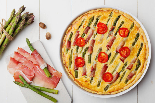 Tart with asparagus and tomatoes on white wooden background. - Fotoğraf, Görsel