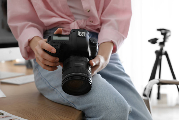 Professional photographer with camera working in office, closeup - 写真・画像