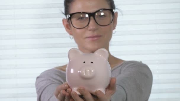 kobieta wprowadzenie monet do piggy bank - Materiał filmowy, wideo