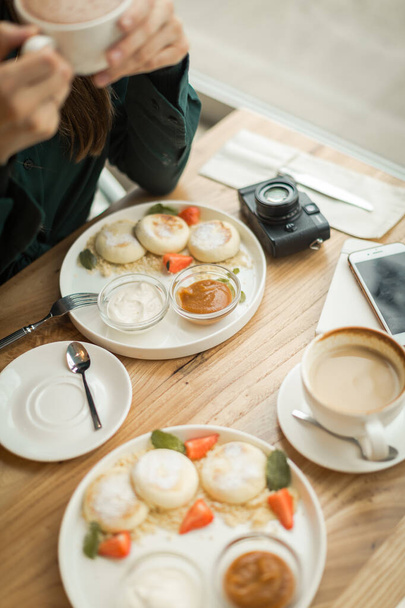 young girl on a date at breakfast with a camera - Foto, afbeelding