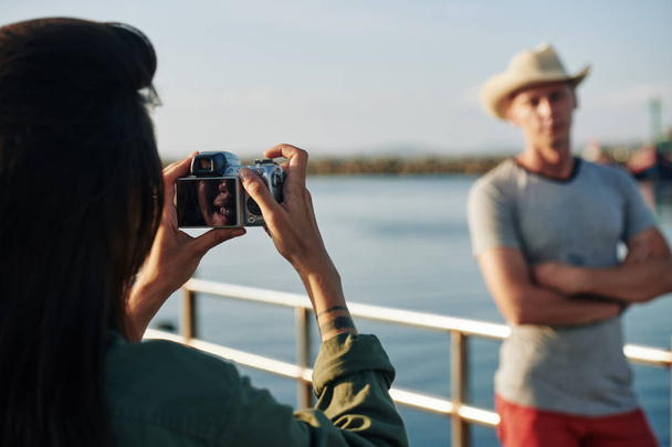 Mulher alegre usando câmera digital ao fotografar seu marido durante a viagem curta, foco seletivo
 - Foto, Imagem