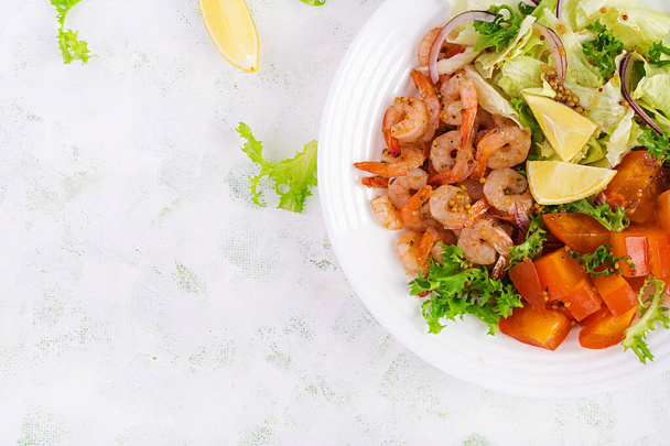 Fruit salad with fried prawns / shrimps, persimmon, red onion and lettuce in white bowls. Appetizers, snack, brunch. Healthy food. Top view, overhead, copy space - Photo, Image
