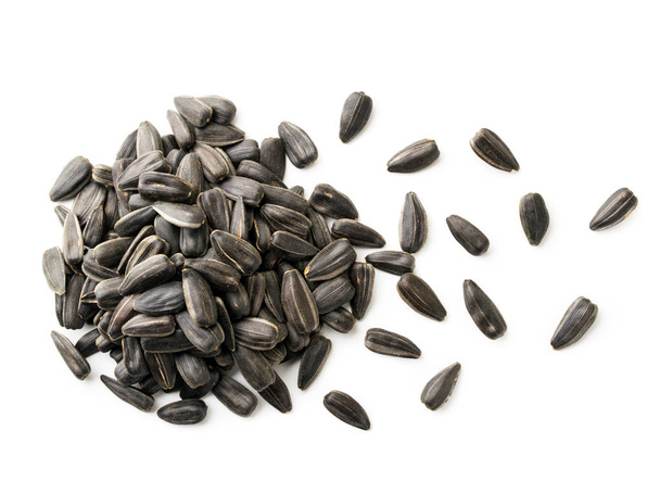 Pilha de sementes de girassol e grãos espalhados em um fundo branco. A vista do topo
 - Foto, Imagem