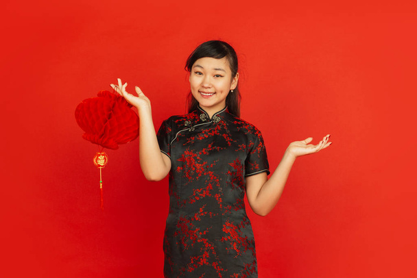 Happy Chinese new year. Asian young girlss portrait isolated on red background - Photo, Image