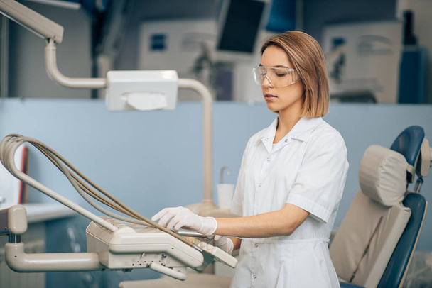 mujer dentista grave que utiliza equipo médico en el trabajo
 - Foto, Imagen