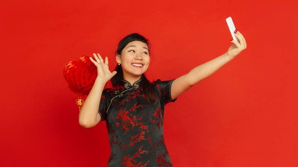 Happy Chinese new year. Asian young girlss portrait isolated on red background - Photo, Image
