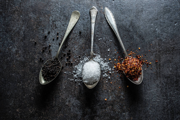 Three spoons full of salt chilli and black pepper - Foto, afbeelding