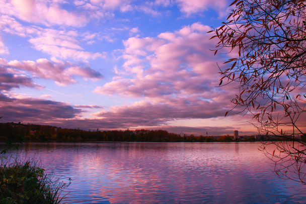 Gyönyörű őszi táj tükröződik a felhők a tóban. Vidéki környezet a víz szélén növényzettel a háttérben. - Fotó, kép