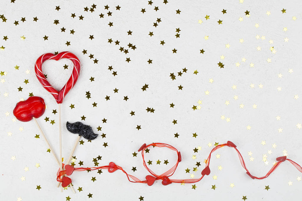 sucette rouge et noire en forme de coeur, lèvre et moustache sur fond blanc avec des étoiles dorées
. - Photo, image