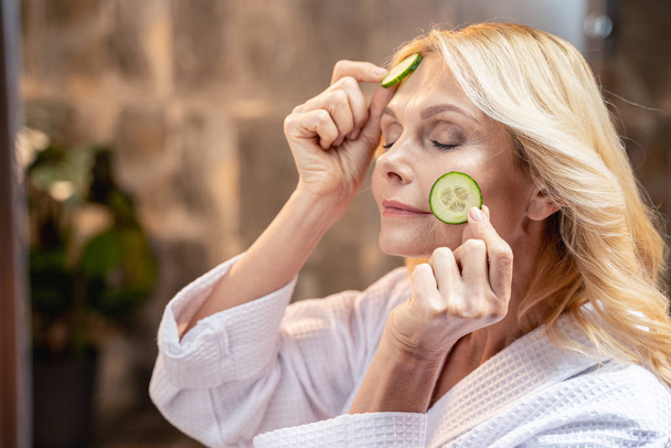 Mature woman relaxing with a facial mask - Photo, image