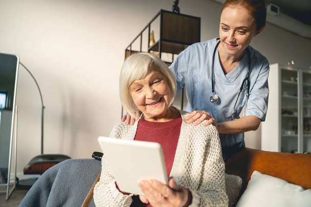 Positive delighted pensioner demonstrating her new tablet - Фото, изображение