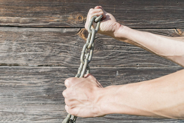 Men's hands tied with a metal chain - Foto, Bild