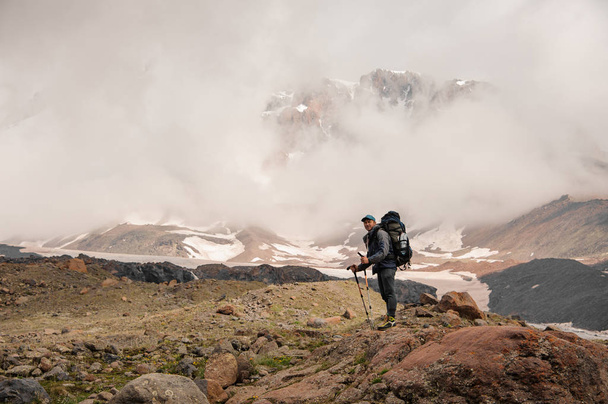 Traveller stands on top of the foggy mountain - Valokuva, kuva