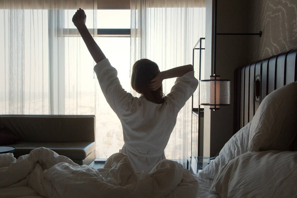 Movilidad en la parte superior del cuerpo, hermosa mujer joven estirándose en la cama después de despertar
 - Foto, Imagen