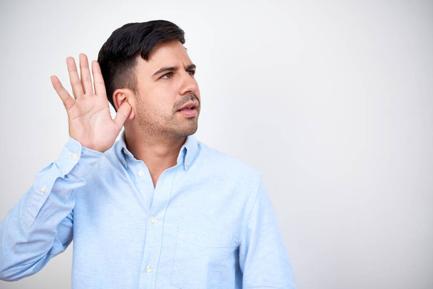 Jeune homme d'affaires tenant la main près de l'oreille quand écouter des rumeurs
 - Photo, image
