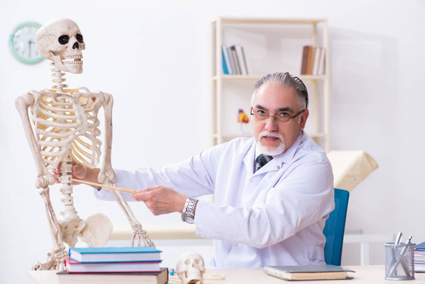 Médico varón envejecido con esqueleto - Foto, Imagen