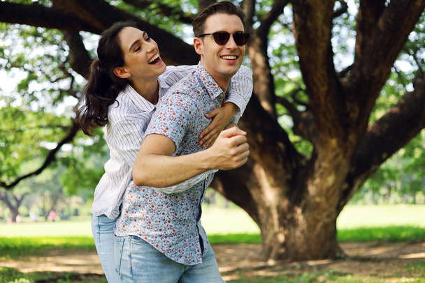 Młode pary cieszą się i są szczęśliwe podczas wakacji w parku ogrodowym. - Zdjęcie, obraz
