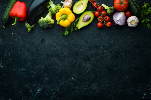 Fresh vegetables in wooden box on black stone background. Tropical fruits. Top view. Free space for your text. - 写真・画像