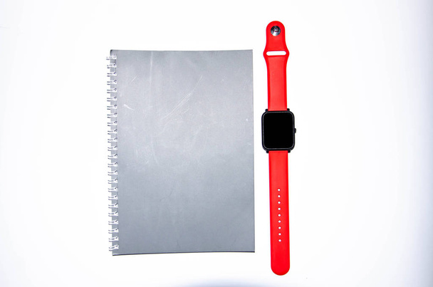 Gray notebook for writing on black background. Ballpoint pen. Smart watch with a red strap. Flat Lai, copies of the paste. View from different sides. Smartphone. Businessmen set kit white background. - Photo, Image