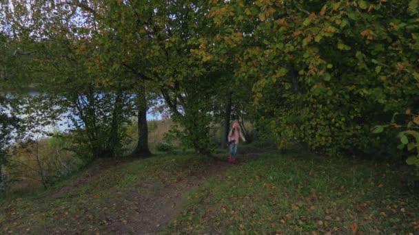 Happy Little Girl with headphones walking alone in park - Felvétel, videó