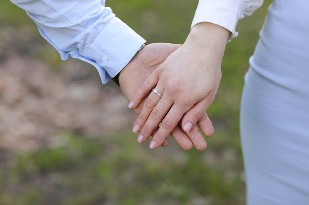 pareja en el amor se toman de la mano en el campo verde en verano. primer plano foto
 - Foto, imagen