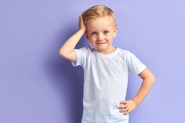 Adorable child with blond hair and blue eyes isolated on purple background - Φωτογραφία, εικόνα