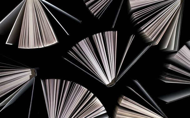 Ansicht von halb geöffneten Büchern auf schwarzem Hintergrund - Foto, Bild