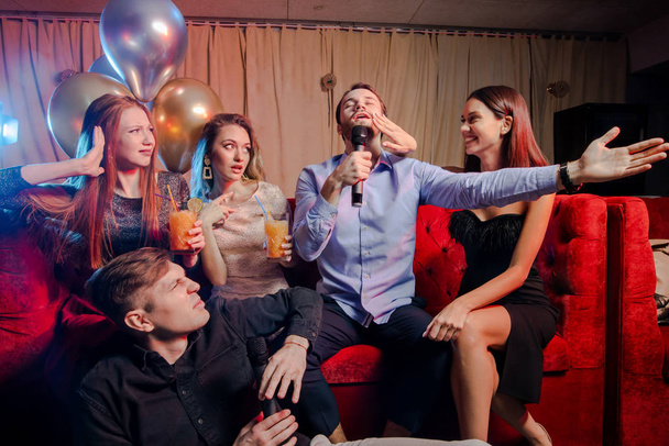 Jóvenes caucásicos bailan y cantan en el club de karaoke
 - Foto, imagen