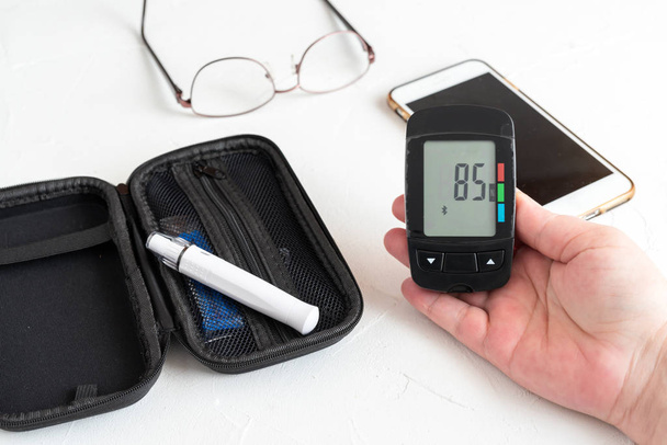 Mains du patient mesurant le taux de glucose Test sanguin avec glucomètre
 - Photo, image