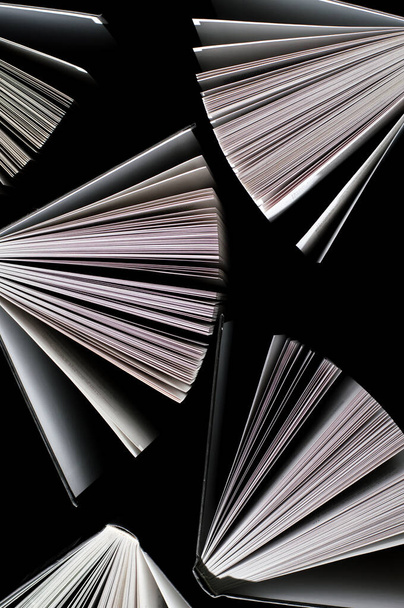 top view of half-opened books on black background - Valokuva, kuva