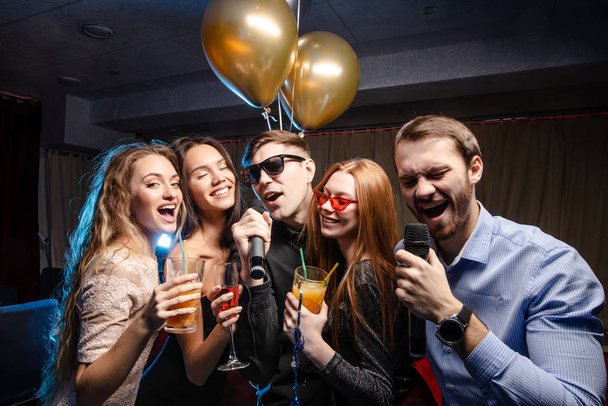 young people celebrating birthday in karaoke bar - Photo, Image