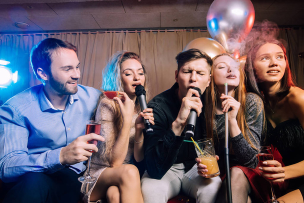 fiatal klubok töltenek időt karaoke bárban - Fotó, kép