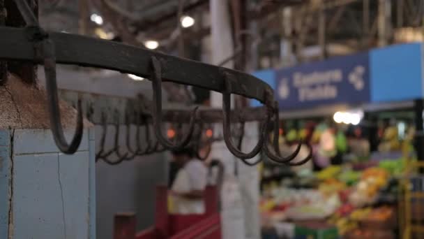 Κοντινό πλάνο άδειων γάντζων κρέατος σε μια αγορά τροφίμων. Ντόλι αριστερά - Πλάνα, βίντεο